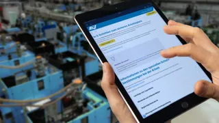 Sicherheitsfachkraft in Produktionsstätte informiert sich über die sichere Arbeitsplatzgestaltung.