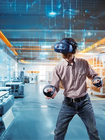 Ein Mann steht in einem Raum. Er hat eine VR-Brille auf und taucht in die virtuelle Realität ab.