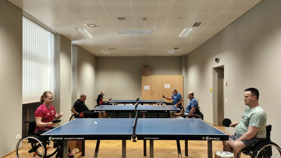 Rollstuhltischtennis: Im Bild sind eine Spielerin und fünf Spieler an drei Platten