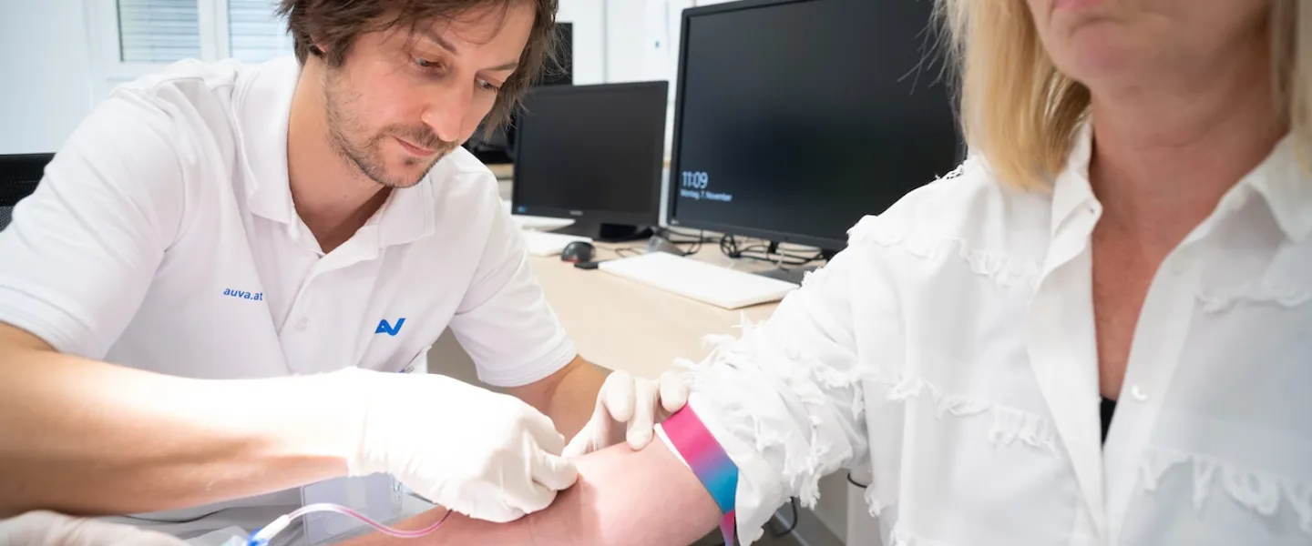 Ein Arzt führt bei einer Patientin eine Blutabnahme durch Ein Arzt führt bei einer Patientin eine Blutabnahme durch