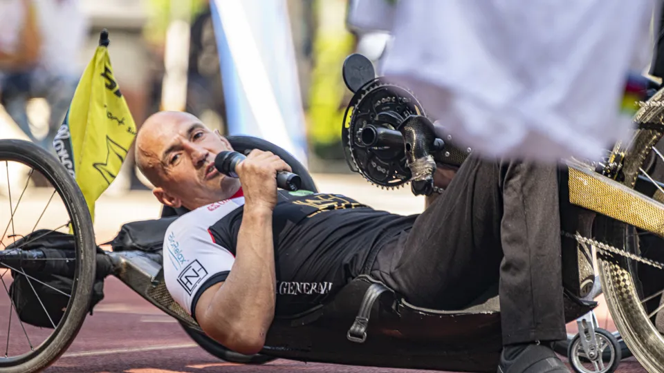 Moderator des Sportfestes liegt auf einem Handbike und spricht ins Mikrofon