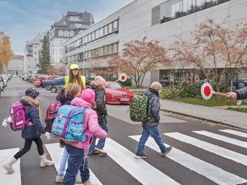 KFV DSC0083 1440(C) KFV Bildstadt Kinder beim Überqueren eines Zebrastreifens, der von Schülerlotsen gesichert wird.