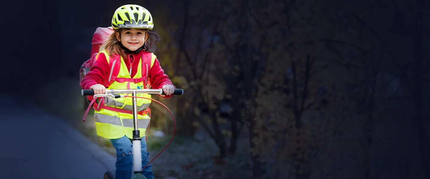 Blog Roller Credit CAP Kindersicherheit, Steiger Mädchen mit Warnweste auf Tretroller im Dunkeln