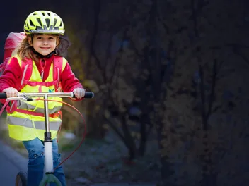 Blog Roller Credit CAP Kindersicherheit, Steiger Mädchen mit Warnweste auf Tretroller im Dunkeln