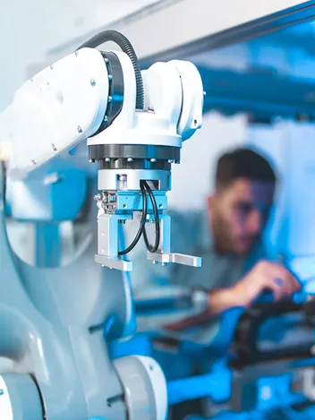 Im Vordergrund ein Roboter im Hintergrund das verschwommene Bild eines Mannes Im Vordergrund ein Roboter im Hintergrund das verschwommene Bild eines Mannes
