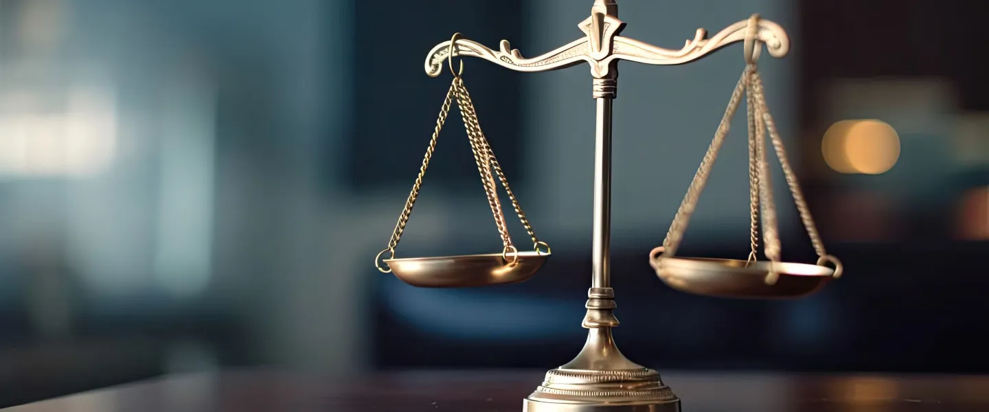 Adobestock 619210258 1440 (C)Barmaleeva Stock.Adobe.Com Waage der Justitia steht auf einem Holz-Schreibtisch