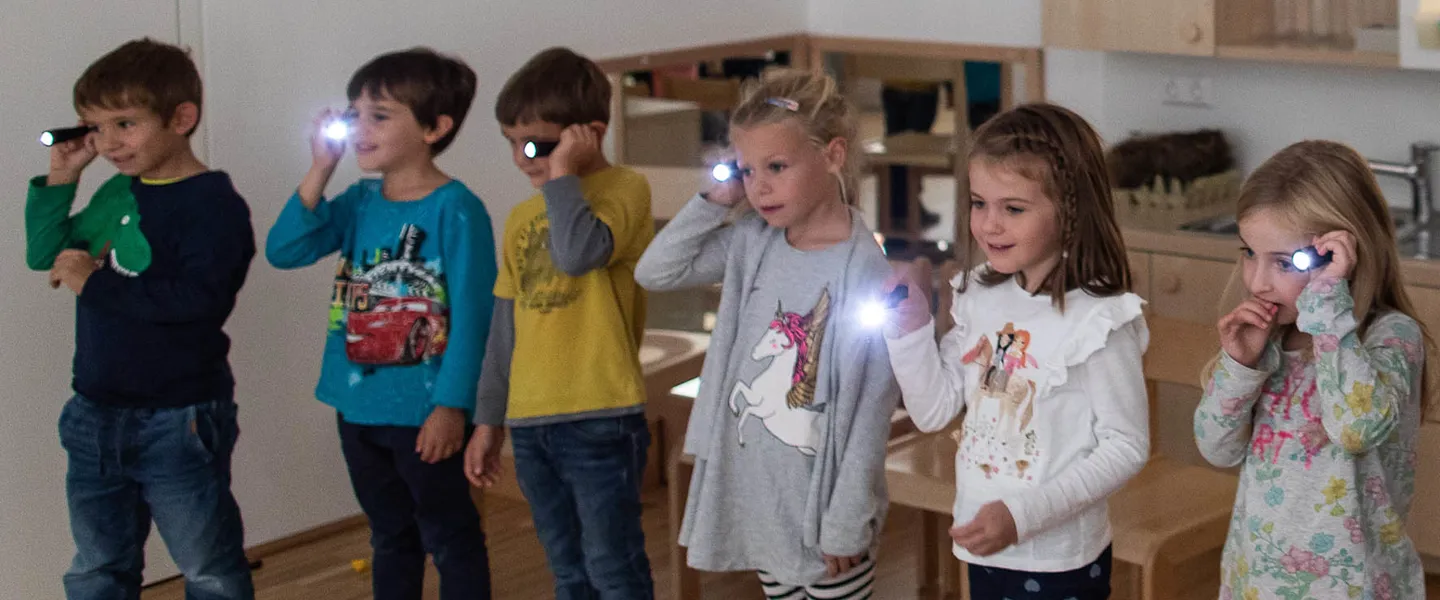 Sechs junge Volkschulkinder lernen im Rahmen der Aktion mit Taschenlampen spielerisch etwas über Sichtweiten im Straßenverkehr.