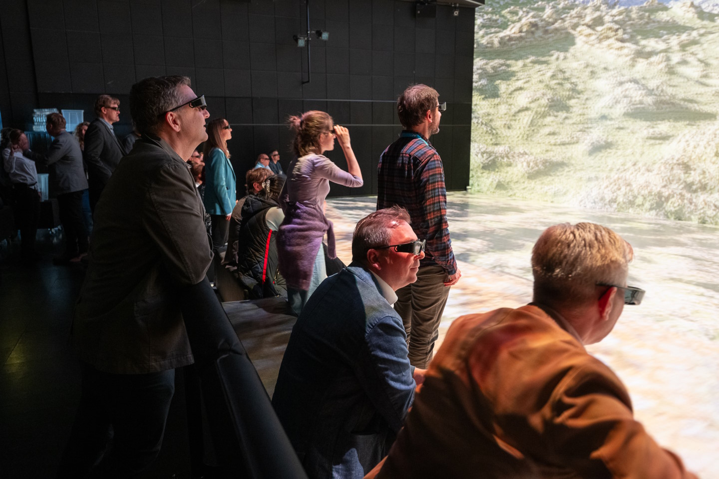 Personen mit VR-Brillen schauen auf eine Projektion