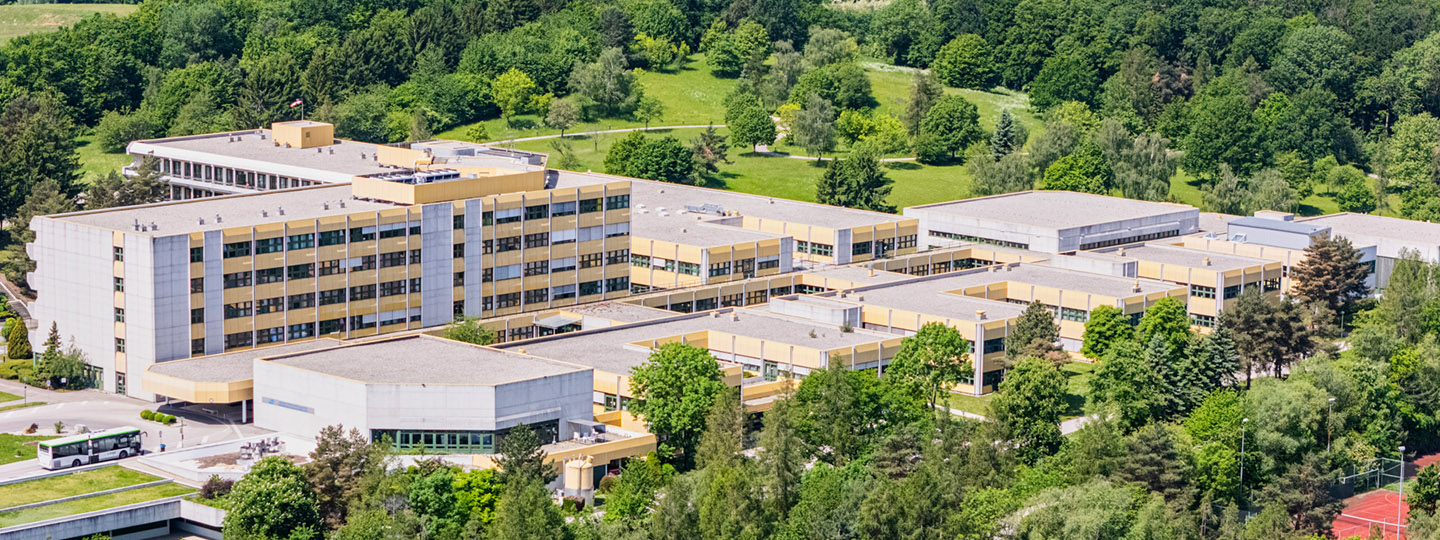 Luftaufnahme des AUVA-RZ Weißer Hof inkl. der umliegenden Parkanlagen und Naturlandschaft