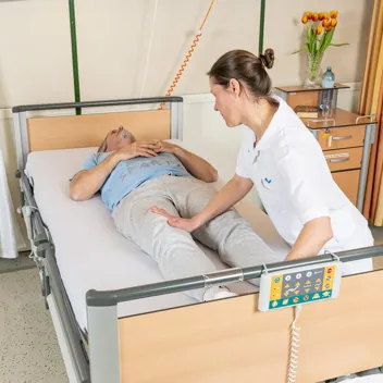 M105 Kinaesthetik Im Bett Nach Oben Rutschen Pflegefachkraft hilft Patient dabei im Bett nach oben zu rutschen
