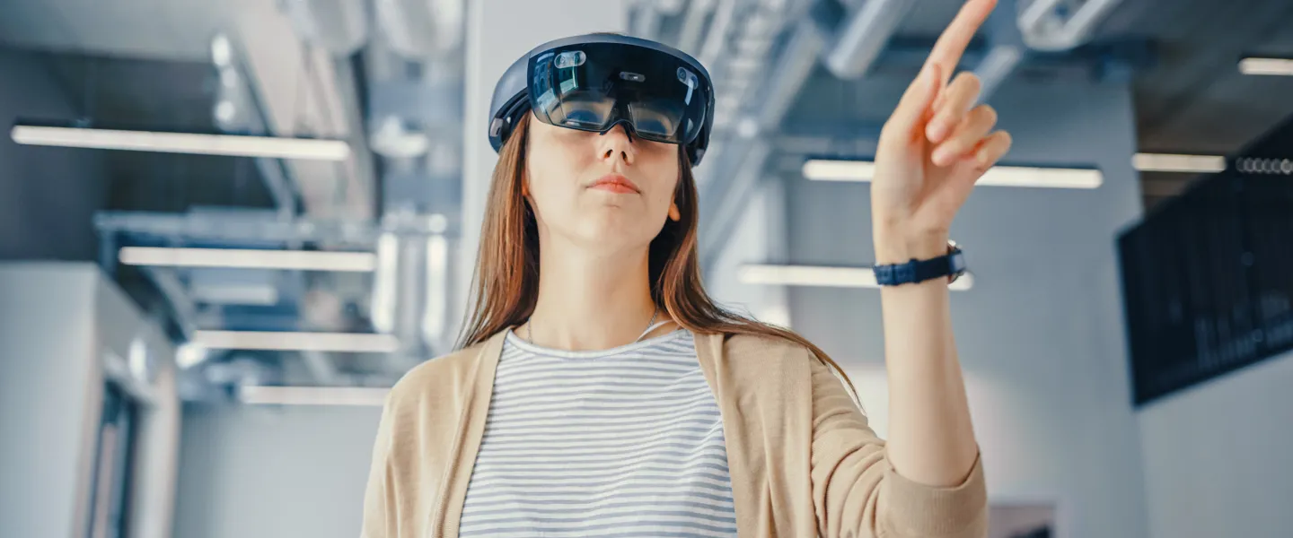 Frau interagiert mit VR-Brille  Frau arbeitet im Büro mit VR-Brille.