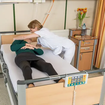 M105 Kinaesthetik Im Bett Zur Seite Rutschen Pflegefachkraft hilft Patient dabei im Bett zur Seite zu rutschen