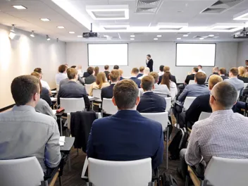 4.3.1_Aus- und Weiterbildung_Firmenseminar_AdobeStock_438364190.jpeg Fachexperte präsentiert in vollem Seminarraum.