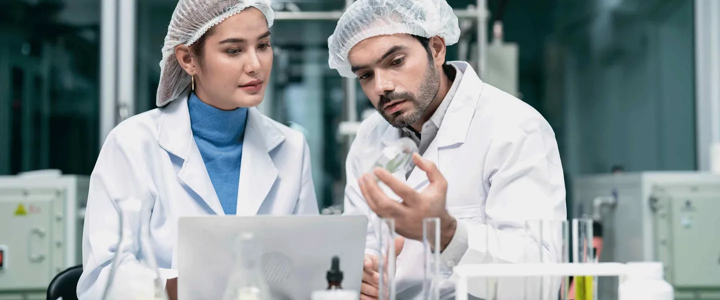 Eine Forscherin und ein Forscher Eine Forscherin und ein Forscher führen in Laborumgebung ein Gespräch