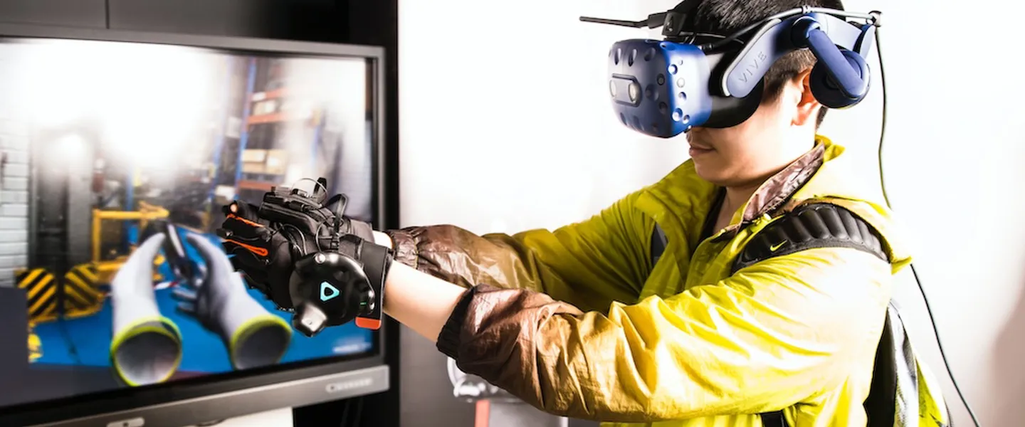 Ein Mann mit Virtual Reality-Brille und Handschuhen beim Ausführen einer Simulation Ein Mann mit Virtual Reality-Brille und Handschuhen beim Ausführen einer Simulation