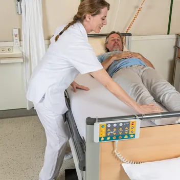 M105 Kinaesthetik Von Der Rueckenlage Zum Querbett Sitz Pflegefachkraft hilft Patient von der Rückenlage zum Querbett Sitz