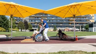 Rollstuhltraining eines Patienten mit Therapeut in den Parkanlagen des AUVA-RZ Häring Rollstuhltraining eines Patienten mit Therapeut in den Parkanlagen des AUVA-RZ Häring