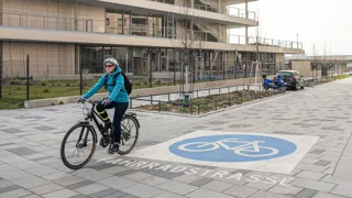 Fahrrad Infoseite 1440 Credit R.Reichhart Frau auf Fahrrad fährt in einer Fahrradstraße