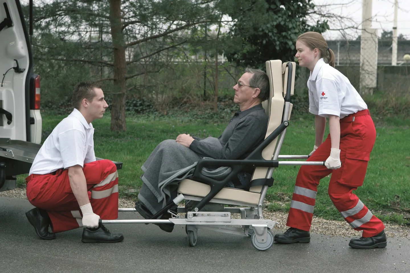 RS683 IU9A7548 1440 Credit ÖRK Anna Stöcher Rettungssanitäter und -sanitäterin beim ergonomischen Anheben eines Patienten auf einem Transportsessels