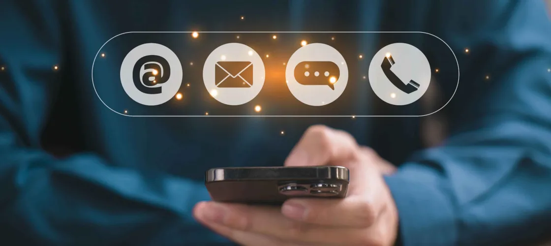 Adobestock 1307231517 1440©VRVIRUS Eine Hand mit Handy und Kommunikations-Icons