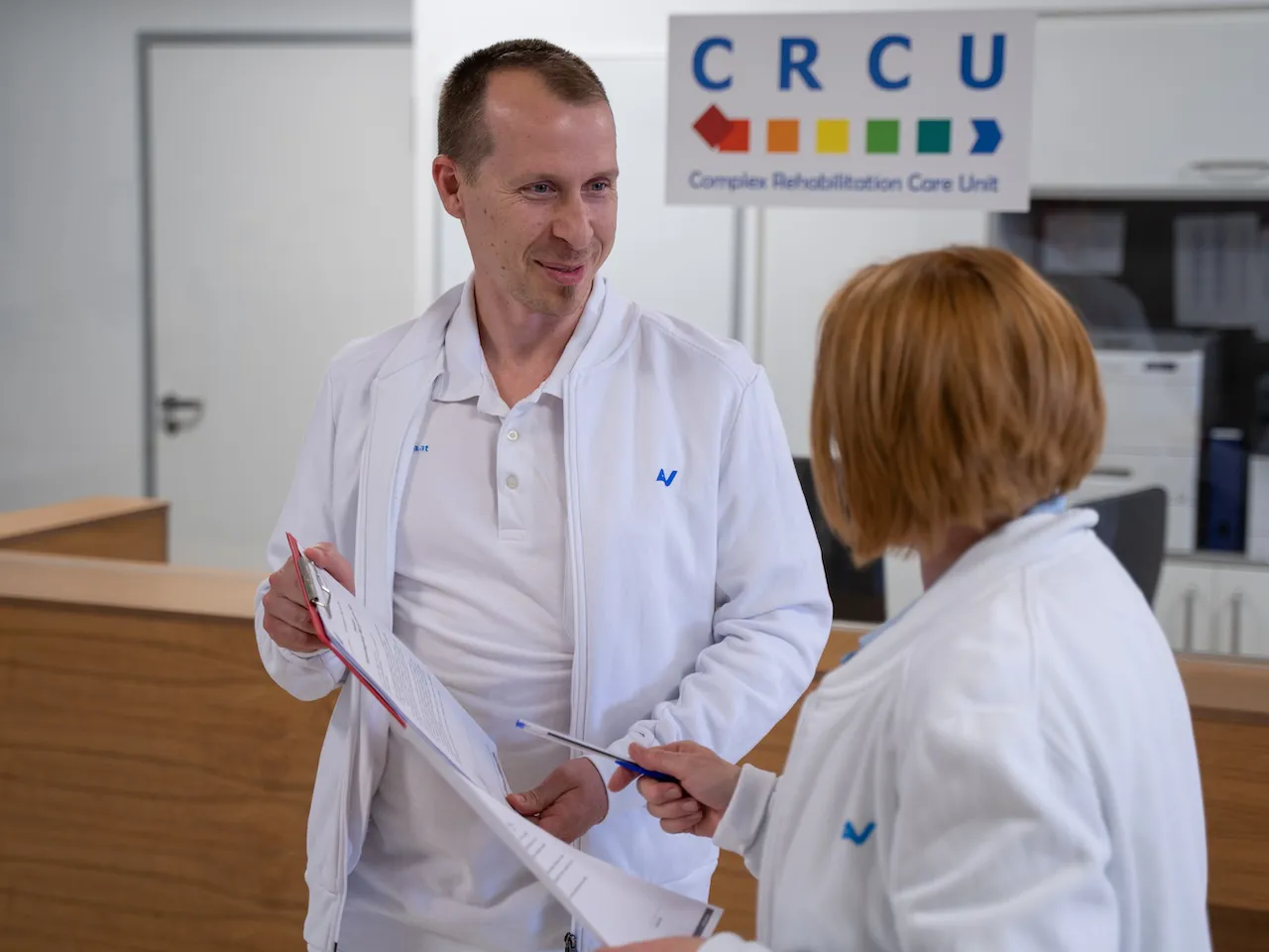 CRCU-Station der unfallchirurgischen Rehabilitation im AUVA-RZ Meidling Zwei Mitarbeitende der Complex Rehabilitation Care Unit im AUVA-RZ Meidling führen eine unkomplizierte Besprechung.