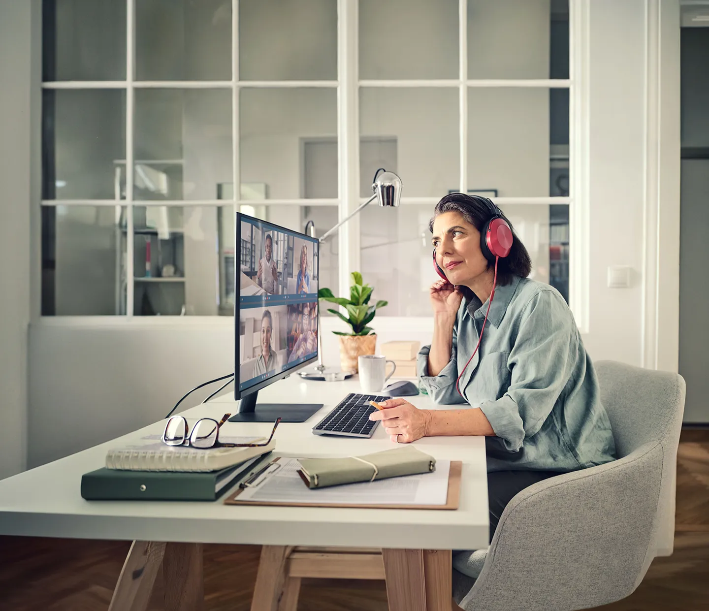 Frau im Mobile Office bei Online Besprechung Eine Person arbeitet im Mobile Office. Sie hört aktiv der Online-Besprechung zu.