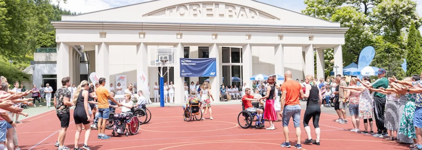 Headerbild Eröffnung Tanz-Performance RKT Sportfest 2023 Bild 1 Bei Tanz-Performance teilnehmende Rollstuhlfahrende, Amputierte, Therapeuten:Therapeutinnen am RKT-Sportfest 2023