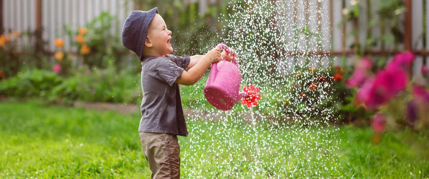 Adobestock 306104321 Bub Spielt Mit Giesskanne Im Garten C Natalialeb 2 Kleiner Bub spielt im Garten mit der Gießkanne
