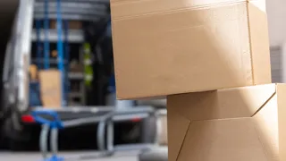 Ungesicherte Kartons liegen vor einem geöffneten Transporter am Boden