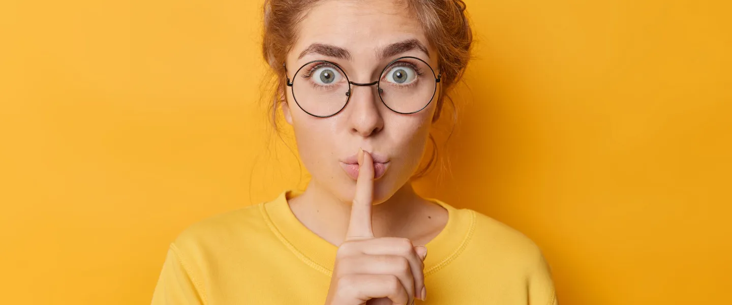 477955020 1440 Credit Wayhome.Studio Adobestock Junge Frau hält den Zeigefinger zur Schweigegeste vor den Mund