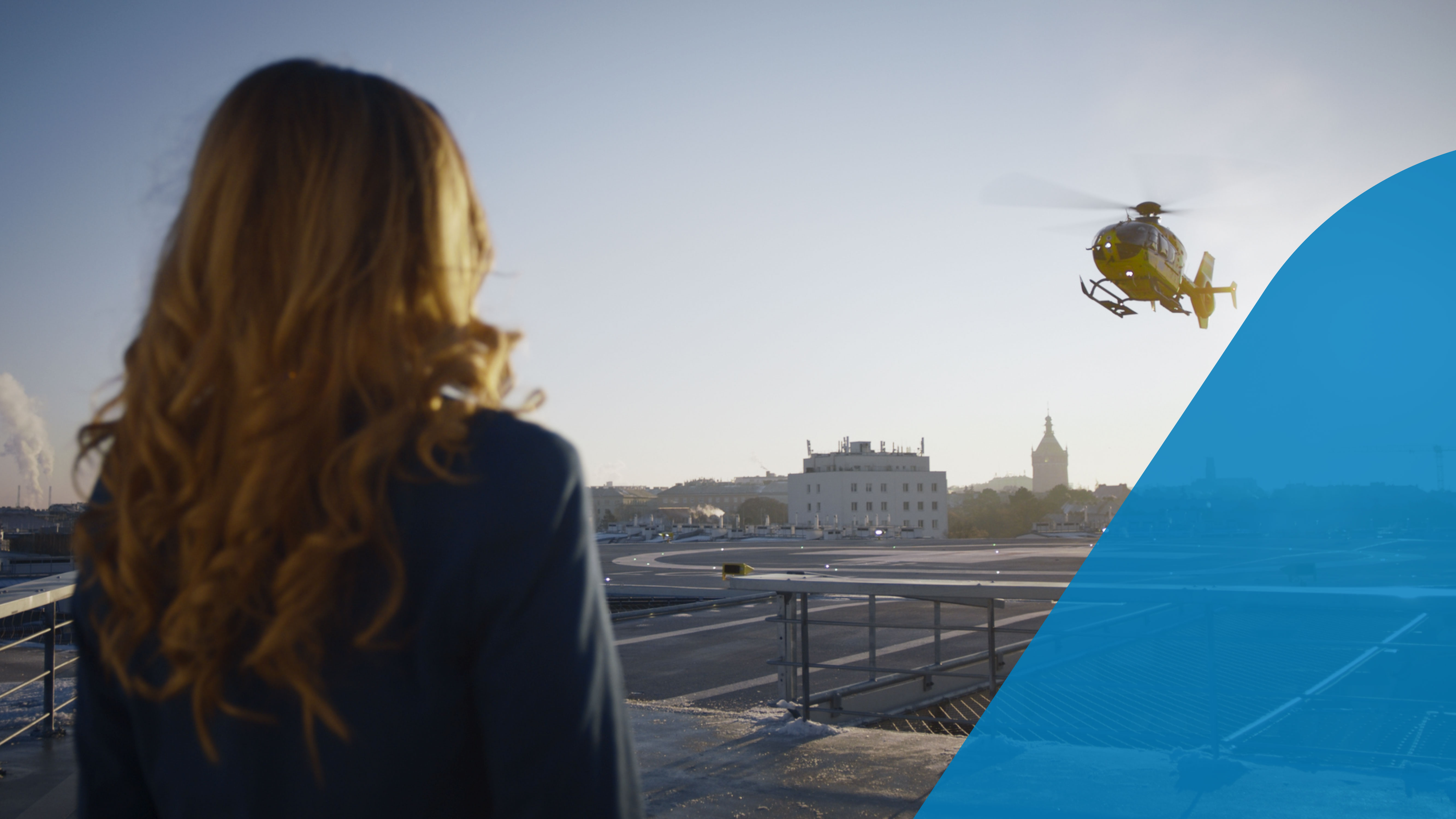 Eine Frau beobachtet in der Nähe des Landeplatzes beim Traumazentrum Wien Meidling die Landung des Rettungshubschraubers 